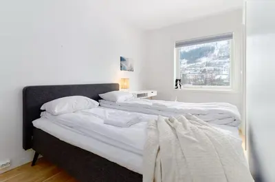 two beds in a white bedroom with a window at 2 bedroom, lake view, light rail, Bergen in Bergen
