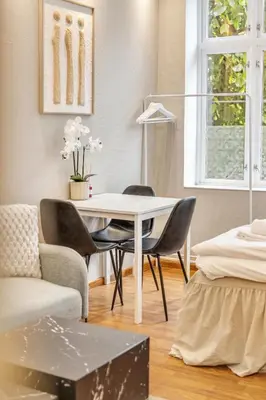 a living room with a white table and chairs at Fløyen Apartments in Bergen