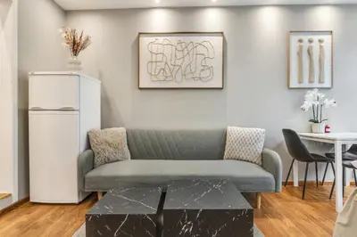 a living room with a couch and a white refrigerator at Fløyen Apartments in Bergen
