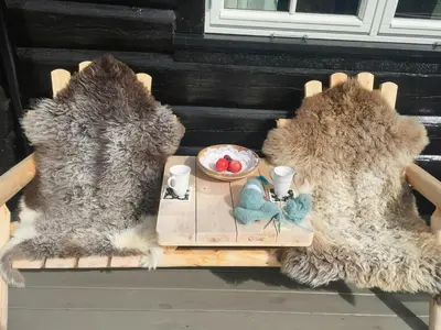 two stuffed animals sitting on a bench with a table at Modern Log Cabin By Hardangervidda in Dagali