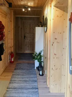 a hallway of a house with wooden walls and a rug at Modern Log Cabin By Hardangervidda in Dagali