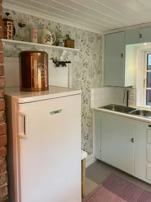 a kitchen with a white refrigerator and a sink at Historic Farm With Sea View Over Bjørnefjorden