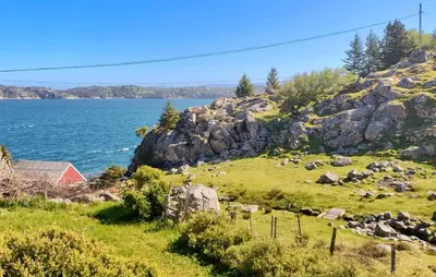 a view of the ocean from a hill with rocks at Beautiful Home In Urangsvåg in Rolvsnes