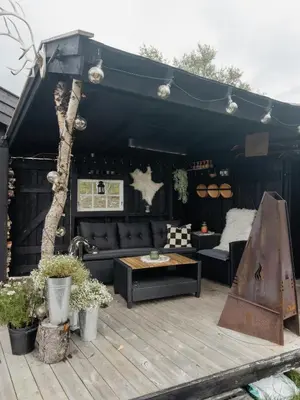 a black tent with couches and a table on a deck at Idyllic Cabin By The Water In Hessdalen in Ålen