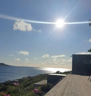 a view of the ocean from a deck at Coastal Cabin With Ocean View On Lepsøya in Kjerstad