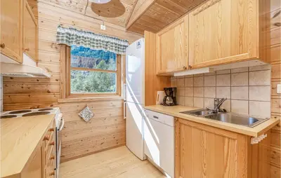 a kitchen with wooden cabinets and a sink at Gorgeous Home In Fjærland in Fjarland