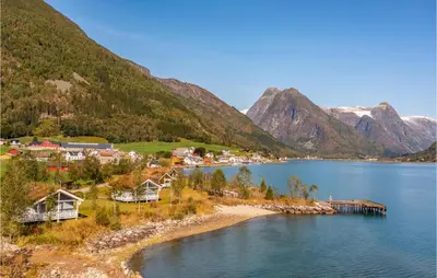 a small town on the shore of a lake with mountains at Gorgeous Home In Fjærland in Fjarland