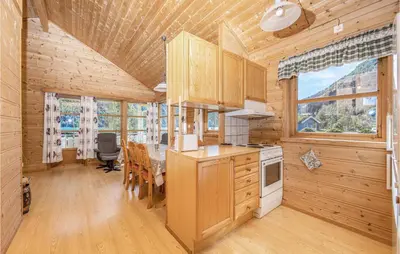a kitchen and dining room with a table in a cabin at Awesome Home In Fjærland in Fjarland