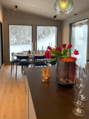 a kitchen with a counter with red flowers in a vase at Family Cabin With Picturesque View At Røn in Ron