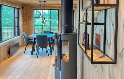 a kitchen with a stove and a dining room with a table at 2 Bedroom Awesome Home In Engerdal in Kvisla
