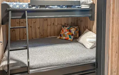 a bunk bed with a ladder and a pillow in a room at 2 Bedroom Awesome Home In Engerdal in Kvisla