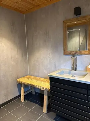 a bathroom with a wooden bench next to a sink at Large and family friendly cabin near Langedrag in Tunhovd