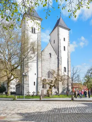 two towers of a building with people walking in front at Bergen Beds Apartment I 100 meters from Bryggen! in Bergen