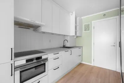 a white kitchen with a sink and a stove at Bergen Beds Apartment I 100 meters from Bryggen! in Bergen