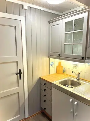 a kitchen with white cabinets and a sink at Modern cabin in amazing hiking area! in Gol