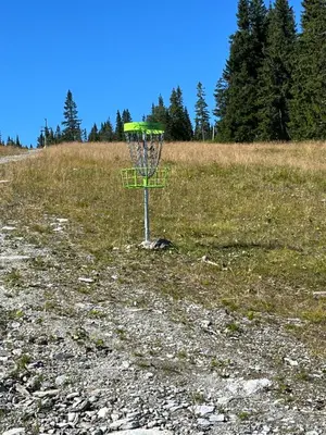 a frisbee golf basket in the middle of a field at Kvitfjell mountain in Strande