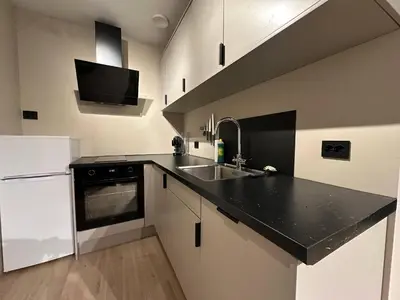a kitchen with a black counter top and a sink at Ålesund Campus Apartments in Ålesund