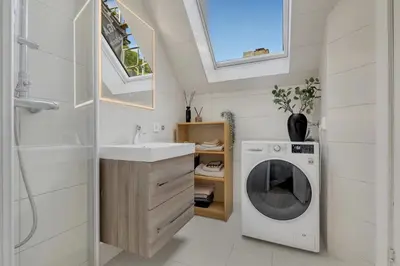a bathroom with a washing machine and a sink at Classic Bergen apartment peaceful space in the city center in Bergen