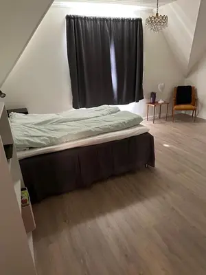 a bed in a room with a black curtain at Panorama Stryn in Stryn