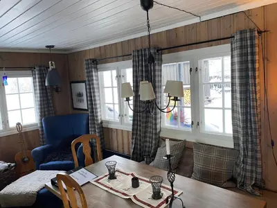 a living room with a table and a couch and windows at Golsfjellet in Gol