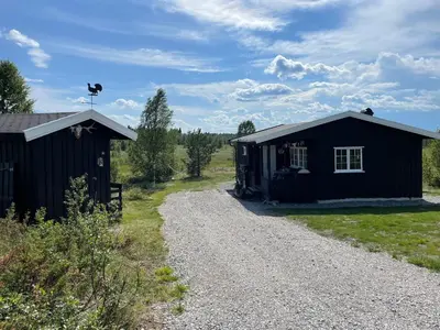a black building next to a gravel road at Golsfjellet in Gol