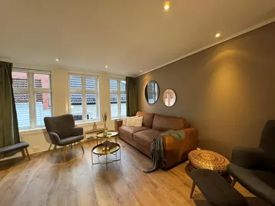 a living room with a couch and a table at Bergenshus rett ved Bryggen i Bergen in Bergen