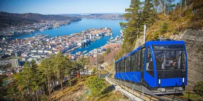 a blue tram on a hill overlooking a river at Moderne Leilighet midt i Bykjernen Apt 1 in Bergen