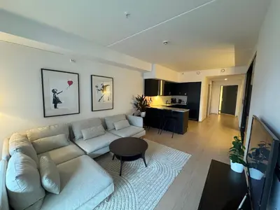 a living room with a couch and a table at Modern three-room apartment, private terrace and roof terrace in Trondheim