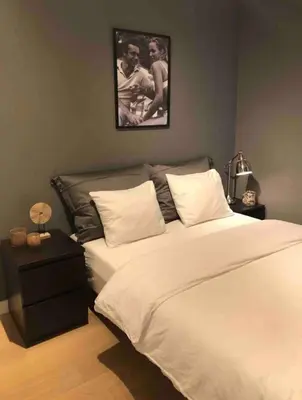 a bedroom with a large bed and a picture on the wall at Moderne Leilighet midt i Bykjernen in Bergen