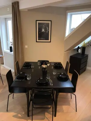 a dining room with a black table and chairs at Moderne Leilighet midt i Bykjernen in Bergen