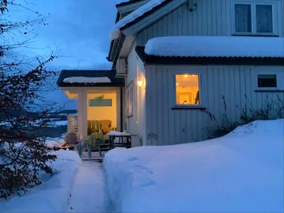 a house with a table and chairs in the snow at Landlige Peru in Ringsaker