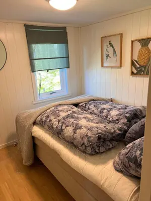 a bedroom with two beds and a window at En Perle ved Masfjorden in Masfjorden