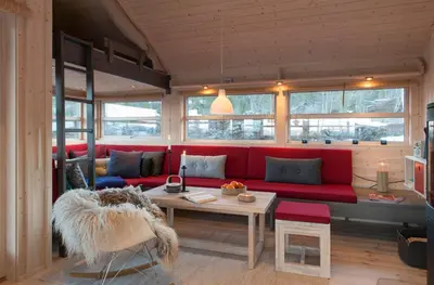 a living room with a red couch and a table at Sørbølhytta by Norgesbooking - cabin in Flå, close to Bjørneparken in Flå
