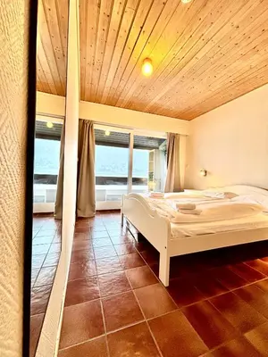 a bedroom with a large bed with a view of the ocean at Faleide Grandview in Stryn