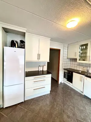 a kitchen with white cabinets and a white refrigerator at Faleide Grandview in Stryn