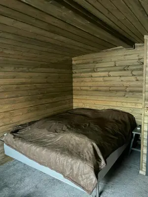 a bedroom with a bed in a wooden wall at Large Familycabin In Fageråsen in Trysil