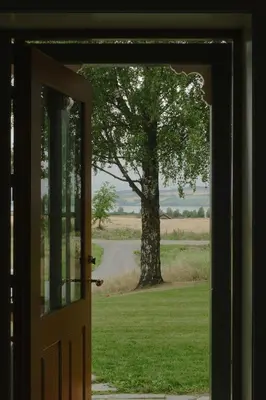 an open door with a view of a tree at Historic Croft With Views Over Lake Mjøsa in Ottestad