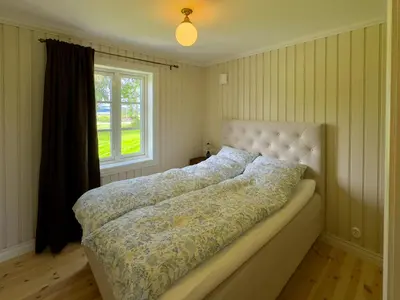 a large bed in a bedroom with a window at Historic Croft With Views Over Lake Mjøsa in Ottestad