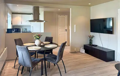 a kitchen and dining room with a table and chairs at 2 Bedroom Cozy Apartment In Laksevåg in Bergen