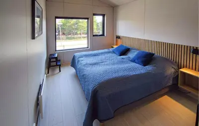 a bedroom with a bed with blue sheets and a window at Amazing Apartment In Bjorli in Bjorli