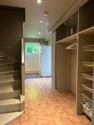 a room with a refrigerator and a hallway with shelves at Casa Gamle Bergen in Bergen