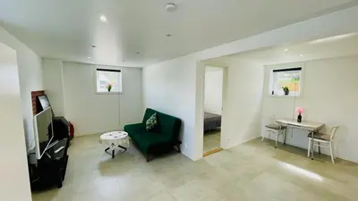 a living room with a green chair and a desk at Cosy One Bedroom Apartment in Hval