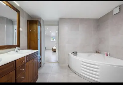 a bathroom with a large tub and two sinks at Cosy One Bedroom Apartment in Hval