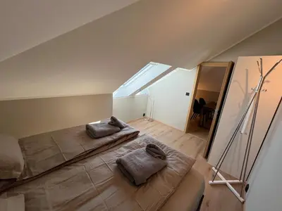 a attic room with two beds and a mirror at Modern Apartment Vaskerelven 12 in Bergen