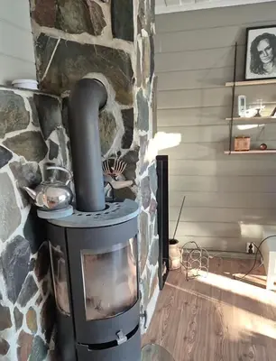 a stone fireplace with a stove in a room at Feriebolig Fannrem in Torshus