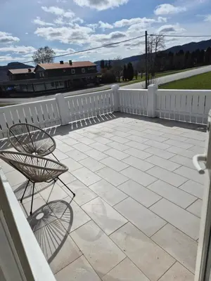 a patio with a white fence and a chair at Feriebolig Fannrem in Torshus