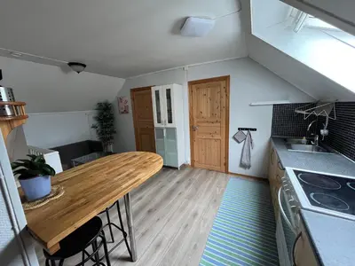 a kitchen with a wooden table in a room at Loft apartment with 3 bedrooms in Trondheim