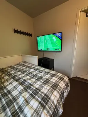 a bedroom with a bed and a flat screen tv at Røldal ski in ski out in Håra