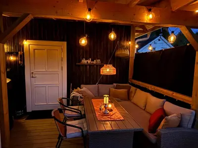 a living room with a couch and a table at Old Farmhouse Retreat with jacuzzi and sauna in Eidsvoll
