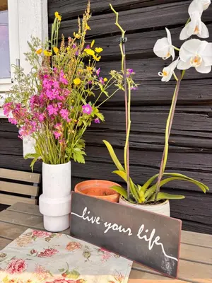 a table with flowers and a sign that reads live your life at Old Farmhouse Retreat with jacuzzi and sauna in Eidsvoll